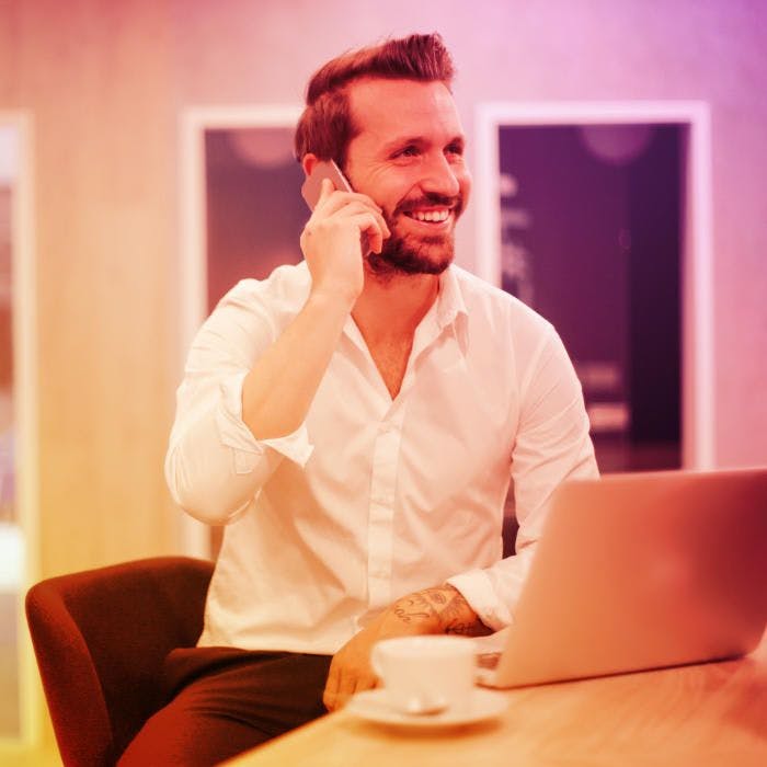 Um homem profissional do setor imobiliário feliz conversando com seus clientes pelo celular